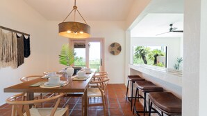 A dining area with a wooden table, chairs, and a hanging light fixture. - Hot Tub/Pool, Views, Pets-Catalina Foothills Casa (Tucson)