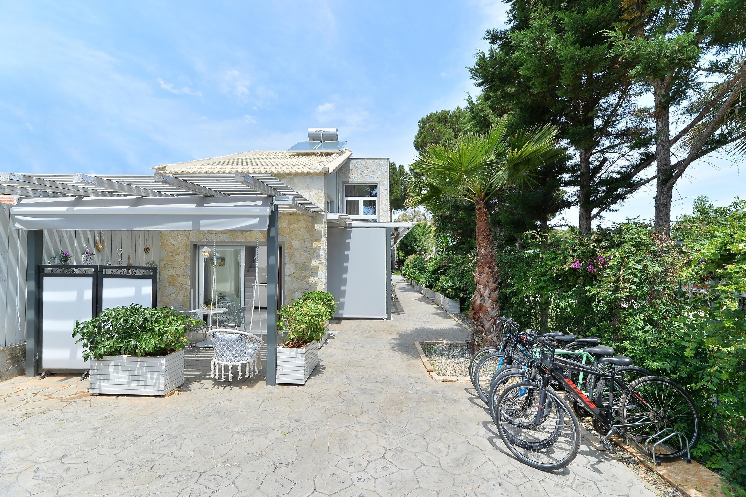 Un edificio con facciata in pietra, un patio coperto e una fila di biciclette parcheggiate davanti.