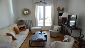 A living room with a sofa, armchairs, a coffee table, a TV, and a radiator. - Nyons ,villa au Cœur des Vignes et des Oliviers Avec Grande Piscine (Nyons)