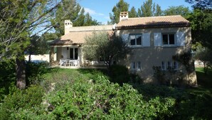 A two-story house with a tiled roof, surrounded by greenery and trees. - Nyons ,villa au Cœur des Vignes et des Oliviers Avec Grande Piscine (Nyons)