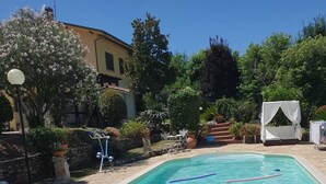 A swimming pool with a stone deck, a lounge chair, and a covered seating area. - Gorgeous shabby rustic on Tuscan hills, pool on request (Capannori)