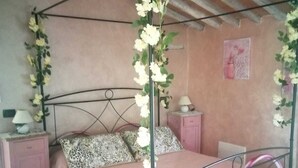 A four-poster bed with white flowers, pink bedding, and a chandelier. - Gorgeous shabby rustic on Tuscan hills, pool on request (Capannori)