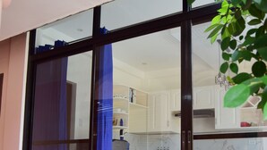 A modern kitchen with white cabinets, a marble countertop, and a sliding glass door leading to a balcony. - A's Place (Valencia)
