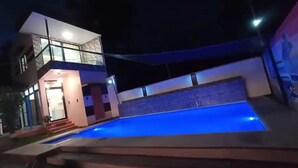 A modern house with a swimming pool at night, illuminated by blue lighting. - A's Place (Valencia)
