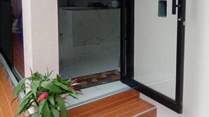 A modern kitchen with white cabinets and a tiled backsplash. - A's Place (Valencia)
