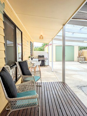 Relax in the covered outdoor space with a grill and comfortable seating.