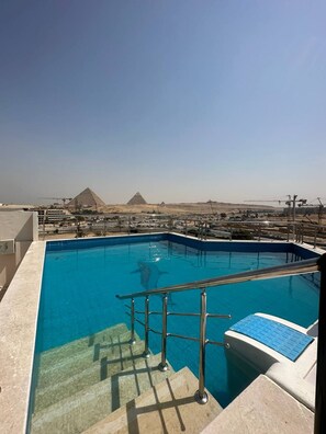 Une piscine avec vue sur les pyramides en arrière-plan.