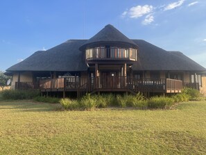 A two-story building with a thatched roof and wooden balconies. - MATORI LODGE (Modimolle)