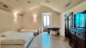 A bedroom with two beds, a television, and a table. - Double Room Mavitur Rooms (Assisi)