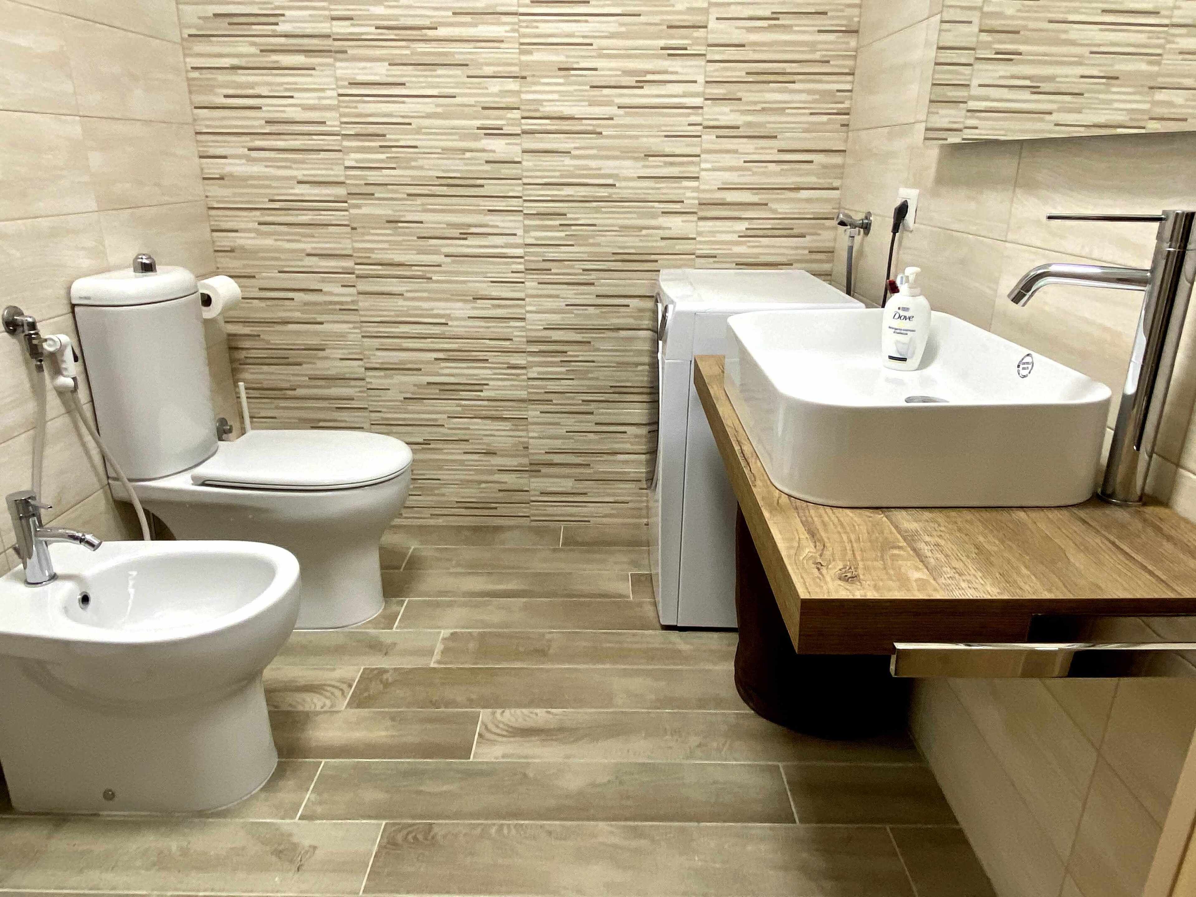 A modern bathroom with a toilet, bidet, and sink.