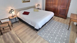 A bedroom with a bed, wooden wardrobe, bedside tables, and a rug. - Spacious Apartment with Terrace & Garage, 10 Min Walk to Park in Colmar (Colmar)