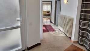 A hallway with a radiator, a striped curtain, and a red patterned rug. - Spacious Apartment with Terrace & Garage, 10 Min Walk to Park in Colmar (Colmar)