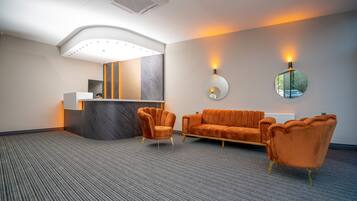 A modern reception area with a curved ceiling, a reception desk, and two sofas.