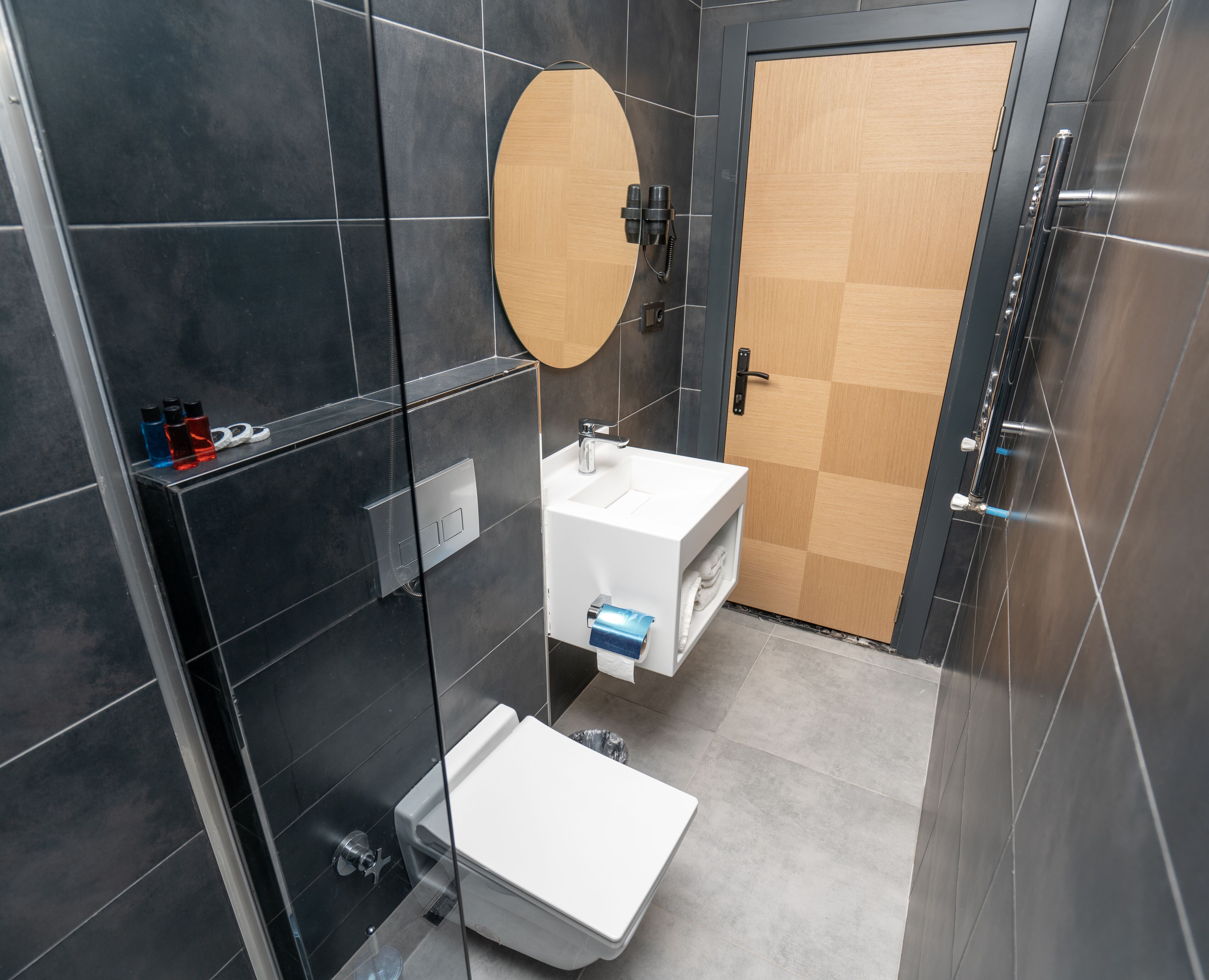 A modern bathroom with a toilet, sink, and mirror.