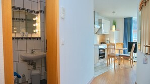 Une chambre d’hôtel moderne dotée d’une salle de bain, d’un coin repas et d’une cuisine.