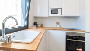 A modern kitchen with a sink, microwave, and dishwasher. - A Casa Das Letras (Cangas)