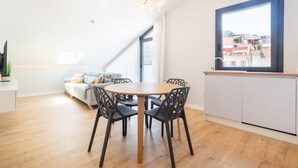 A modern apartment with a dining area, a sofa, and a kitchen. - A Casa Das Letras (Cangas)