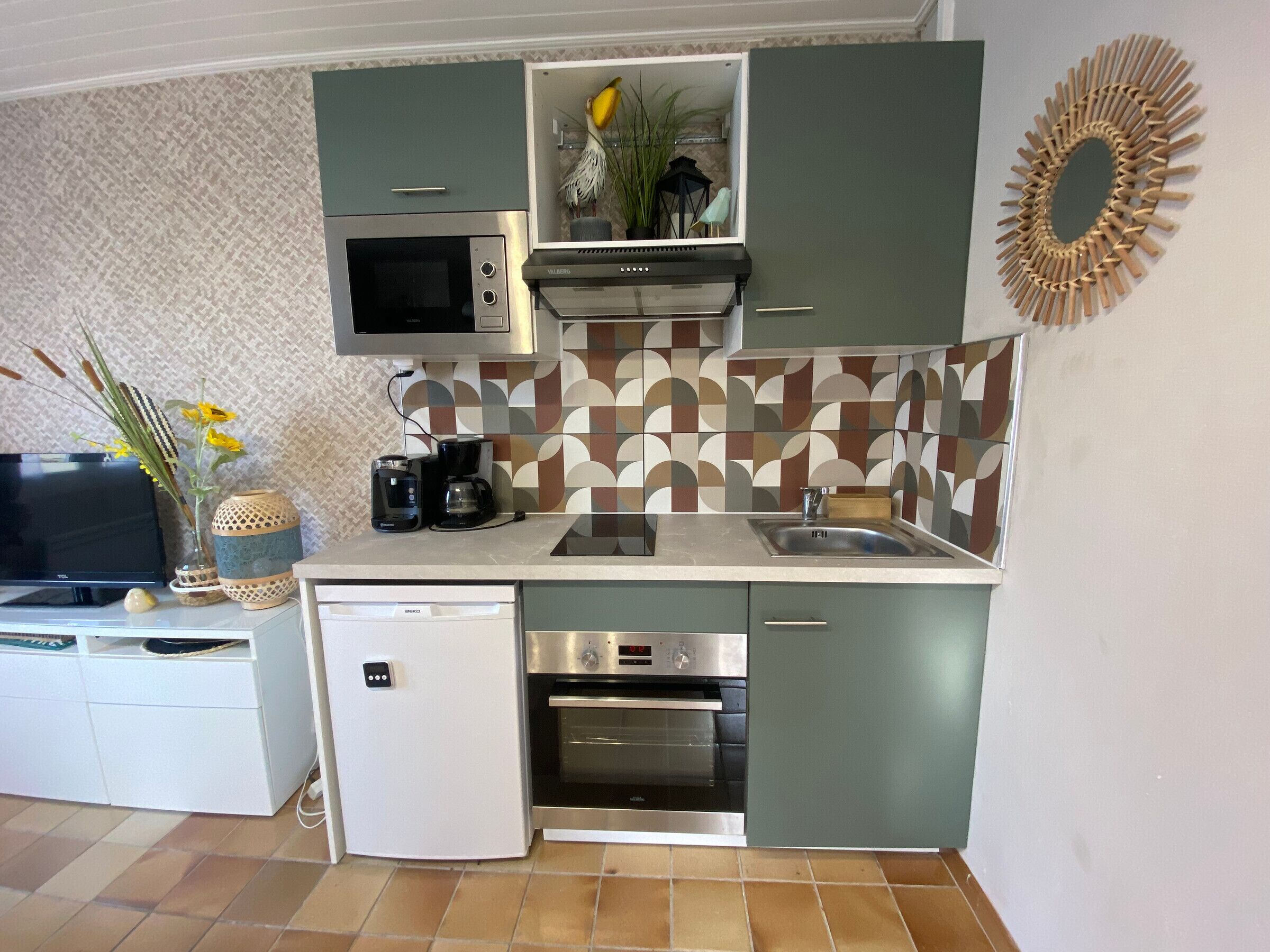 A compact kitchen with a microwave, oven, and coffee maker.