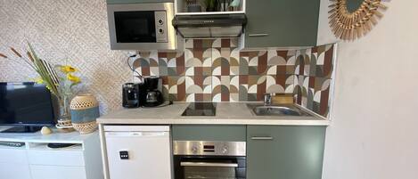 A compact kitchen with a microwave, oven, and coffee maker.