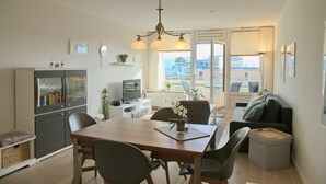 Un espace de vie moderne comprenant un coin repas, une cuisine et un coin salon.