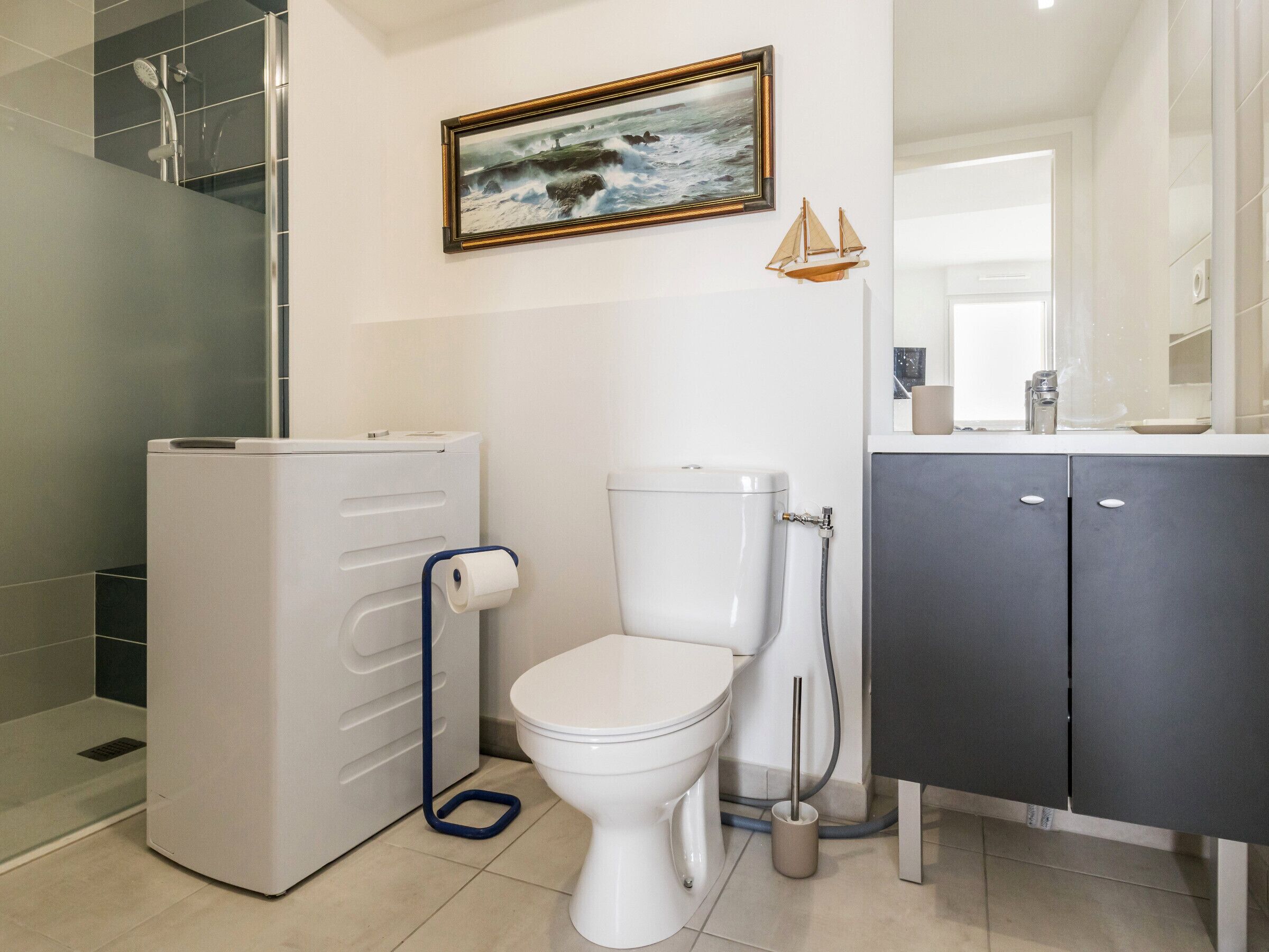 Une salle de bain moderne équipée de toilettes, d’une douche et d’un lavabo.