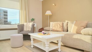A modern living room with a white coffee table, a grey sofa, and a beige couch. - Hanseat II App. 137 (Grömitz)