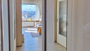 A modern apartment with a view of a cityscape through a large window. - Hanseat I Appartement. 82 (Grömitz)