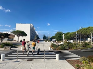 A pedestrian crossing with bollards, a clear sky, and a building in the background.