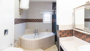 Une salle de bain moderne avec une baignoire sur pieds, une douche et un grand miroir.