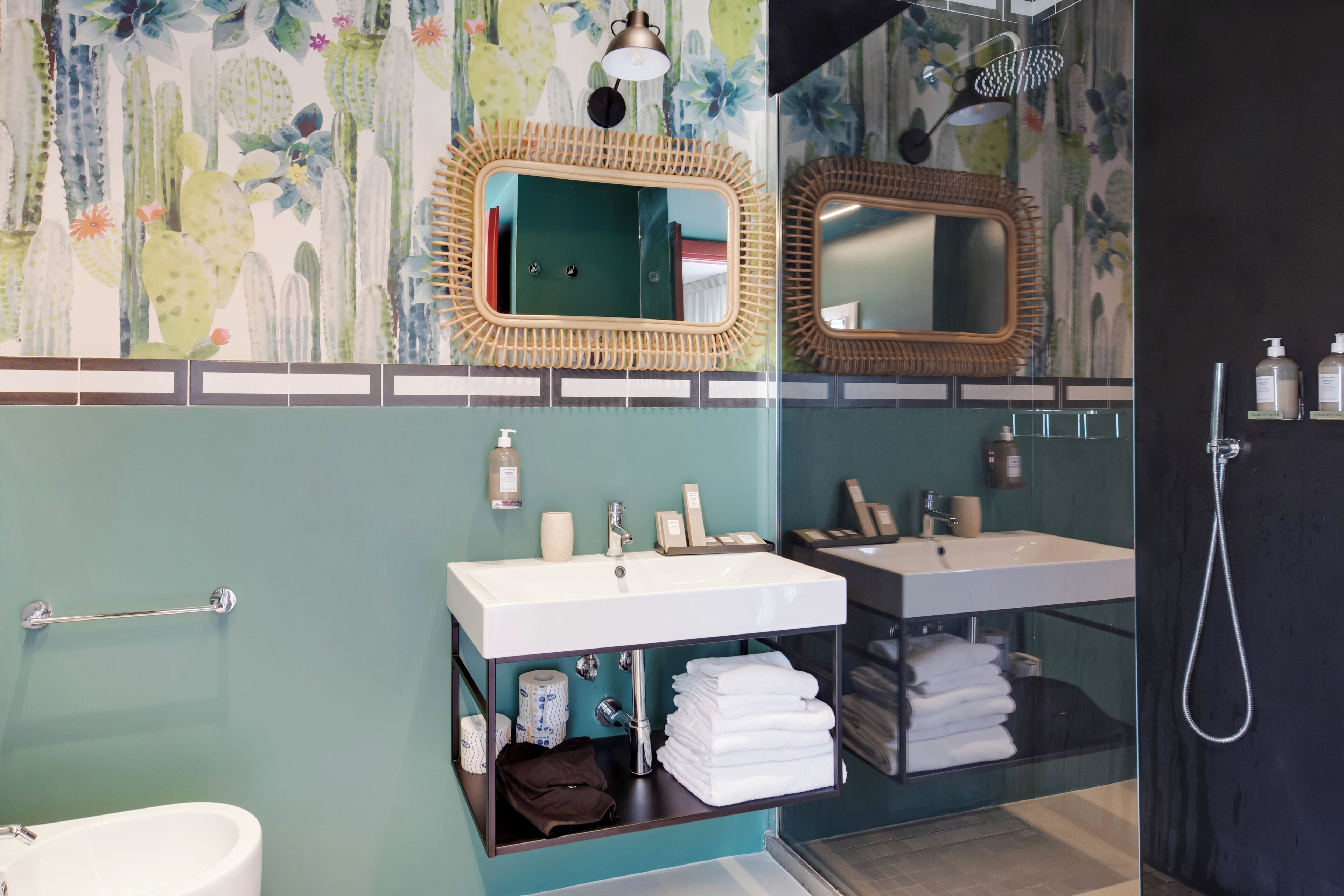 A bathroom with two sinks, a mirror, a shower, and a towel rack.