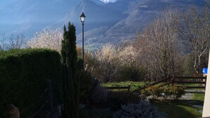 Un paysage montagneux, avec un ciel dégagé, un lampadaire et des arbres en fleurs.