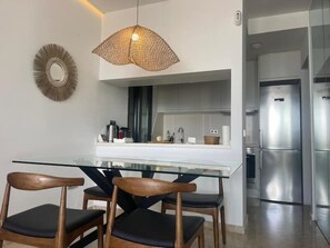 Enjoy meals at the glass-top dining table surrounded by comfortable chairs.