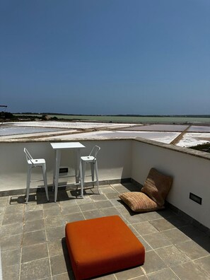 Enjoy a peaceful sea view from this rooftop terrace, featuring a table and chairs for a serene retreat.