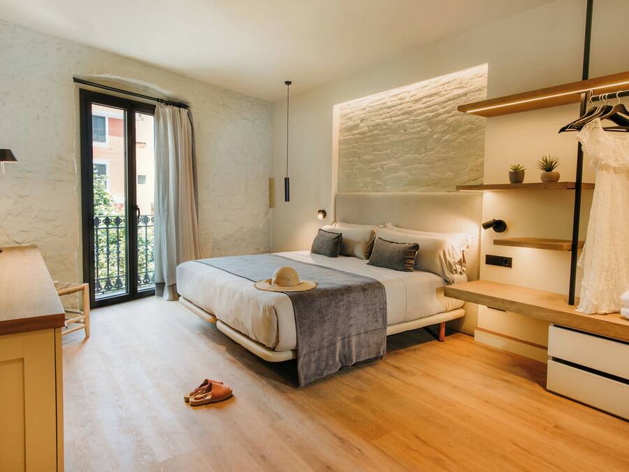 Een moderne slaapkamer met een bed, nachtkastje en een kledingroede.