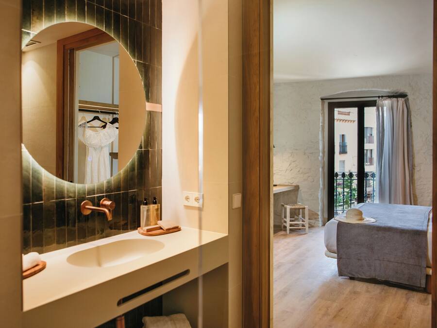 A modern bathroom with a large mirror, a sink, and a towel rack.
