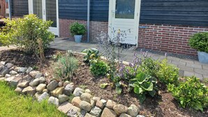 A building with a dark wooden exterior, two white doors, and a sign reading "Weidezucht". - Comfortable Holiday Home With Garden (Hellendoorn)