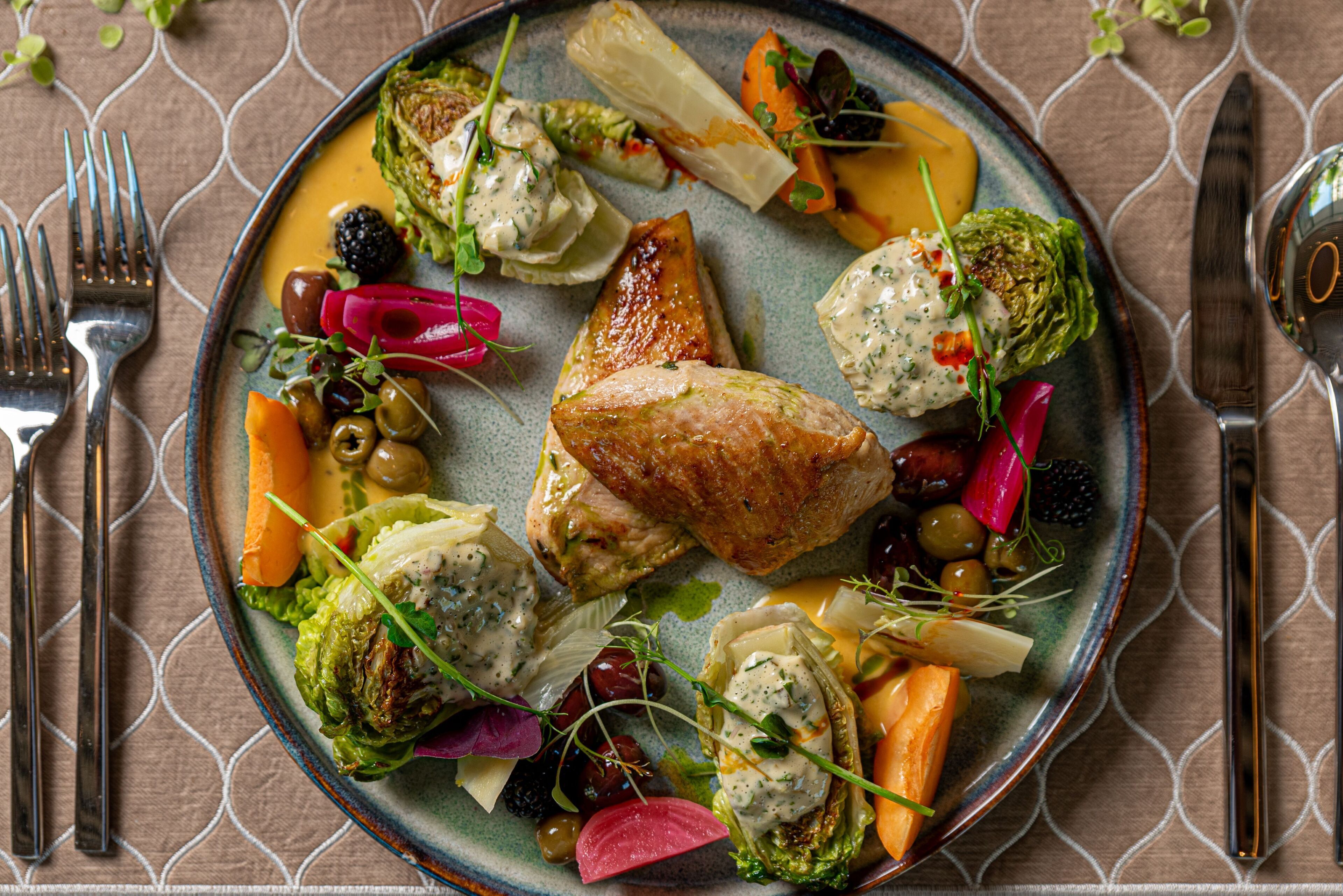 Un plato de comida con varias verduras y un trozo de carne.