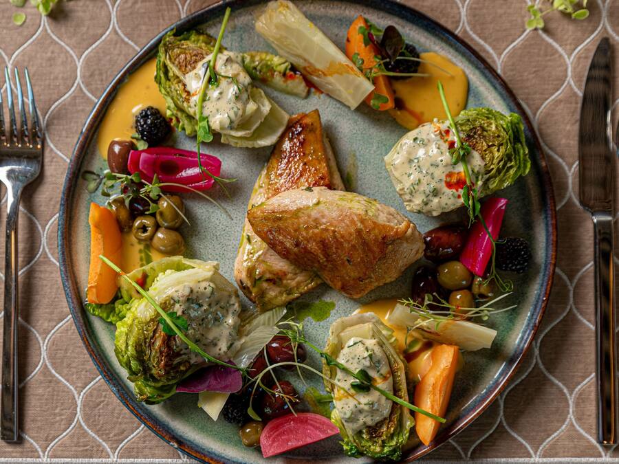 Un plato de comida con varias verduras y un trozo de carne.