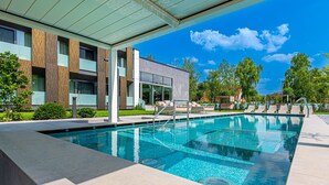 A modern hotel with a swimming pool, outdoor seating, and a covered area. -  REED Boutique HOTEL & BISTRO (Siófok)