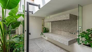 Casa de banho moderna com bancada de granito, um espelho grande e plantas em vasos.