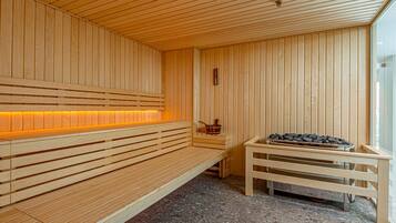 Una sauna de madera con bancos y una piedra hundida.