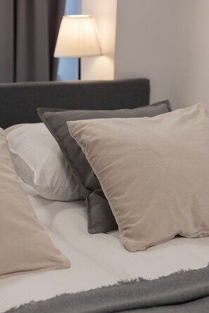 Una cama con varias almohadas y una manta.