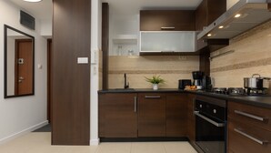 Una cocina moderna con armarios de madera oscura, un horno de acero inoxidable y una cafetera.