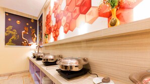 A buffet setup with multiple serving stations, each with covered dishes and a spoon. - OPO THE ALPINO (New Delhi)