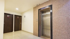 An elevator, two doors, and a wall with a lift sign. - OPO THE ALPINO (New Delhi)