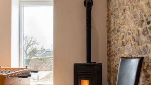 A cozy room with a stone wall, a fireplace, and a foosball table. - Spacious Holiday Home in Doische With Private Pool (Doische)