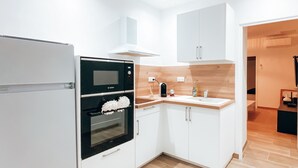 Eine moderne Küche mit weißen Schränken, einem Einbauofen und einer Holz Arbeitsplatte.