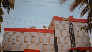 Een gebouw met een rood dak, meerdere schotels en een groot raam.