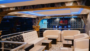 Een luxueus interieur met een bar, leren zitplaatsen en een decoratief wandontwerp.