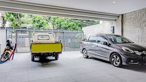 Un garage moderne dans lequel sont garés une voiture argentée et un camion jaune.